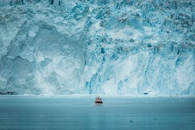 En passagerbåd sejler foran den store, fantastiske isvæg, gletsjeren ved Eqi, i Grønland - Fotograf: Mads Pihl - Visit Greenland