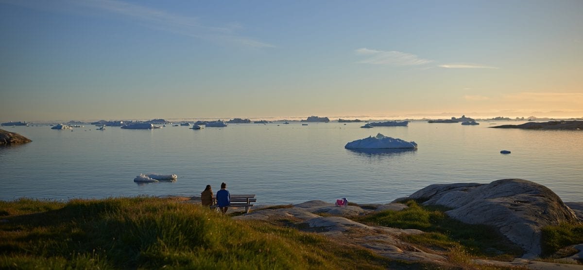 To gæster nyder udsigten over Ilulissat Isfjord fra en bænk i Grønland - Fotograf: Thomas Eltorp, Visit Greenland