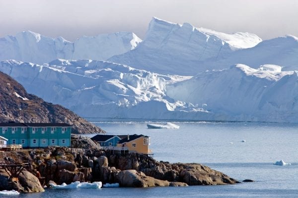 Store, prægtige isbjerge kan ses i baggrunden af Ilulissat by - Fotograf: Glenn Mattsing, Visit Greenland